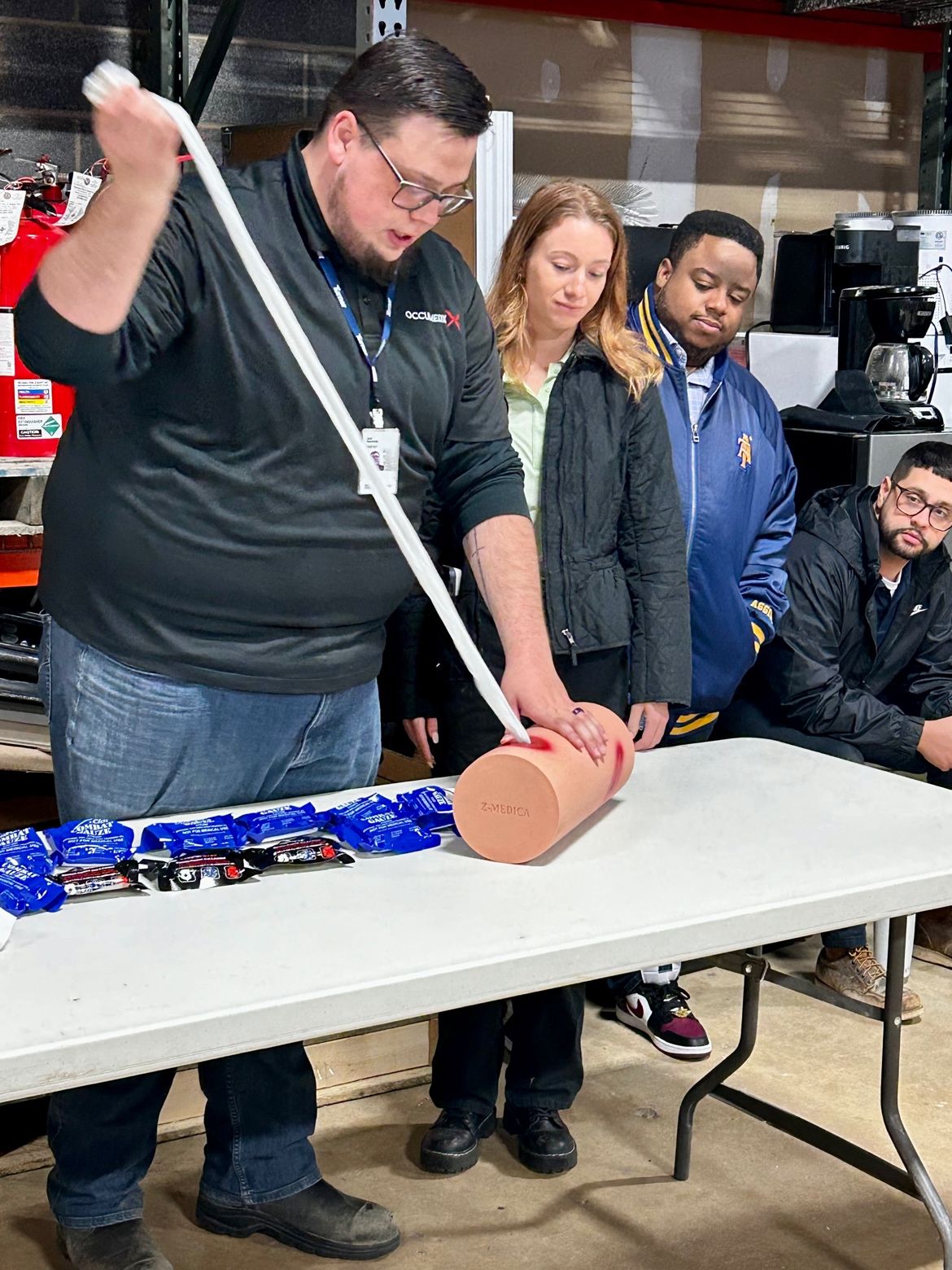 OccuMedX team member leading a hands-on demonstration at a workplace wellness event table